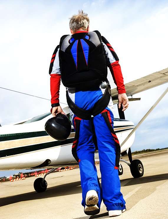 Older man approaching a plane to go skydiving