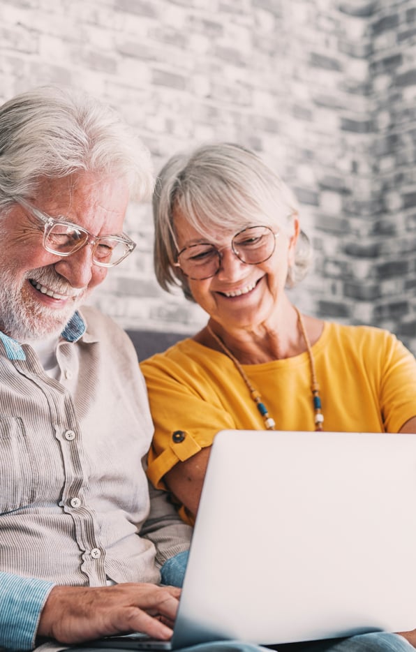 older-couple-shoping Senior couple smiling looking at the laptop